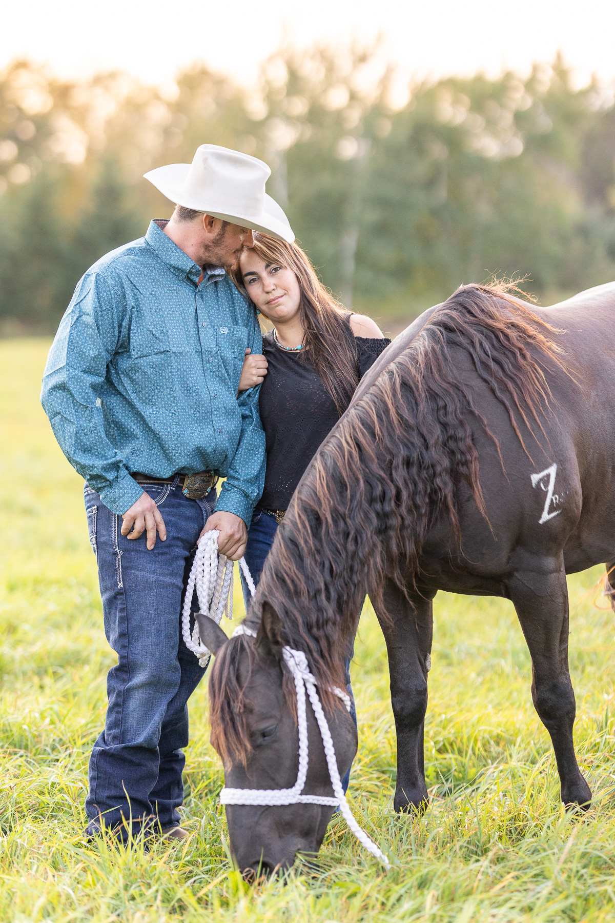 Couples portraits with horses in Stratford, WI, featuring a western couple standing with their horse in a grassy field.